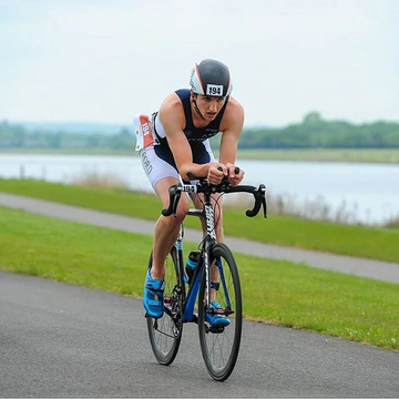 Man riding road bike with clip on aero bars